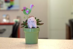 tooth sculpture in flower pot with paper bird