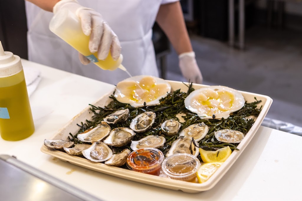 drizzling oil on oyster platter at Lobster Place, New York, NY Fish Market and Restaurant